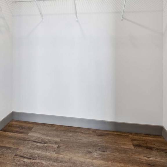 Thumbnail 19 of 35 Empty closet with a white wall and a shelf.
