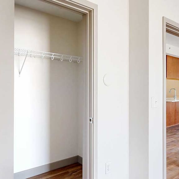 Thumbnail 23 of 24 A wide walk-in closet with a built-in wire shelf.