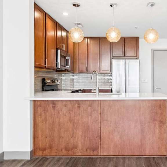 Thumbnail 14 of 20 A kitchen with wooden cabinets and a white counter.