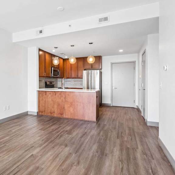 Thumbnail 13 of 20 A kitchen with wooden floors and white walls.