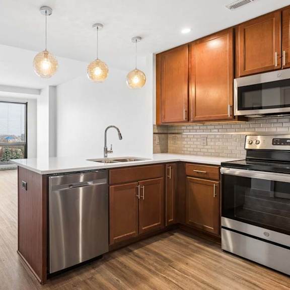 Thumbnail 2 of 20 A modern kitchen with wooden cabinets and stainless steel appliances.