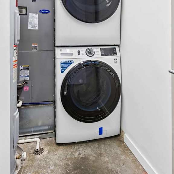Thumbnail 6 of 20 A stacked washing machine is in a small room