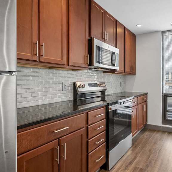 Thumbnail 14 of 19 A kitchen with wooden cabinets and stainless steel appliances.