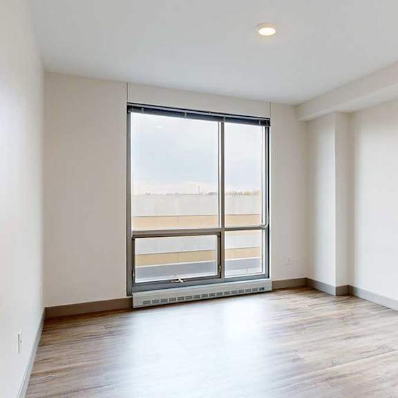 Thumbnail 15 of 24 a bedroom with a floor to ceiling window and hardwood floors