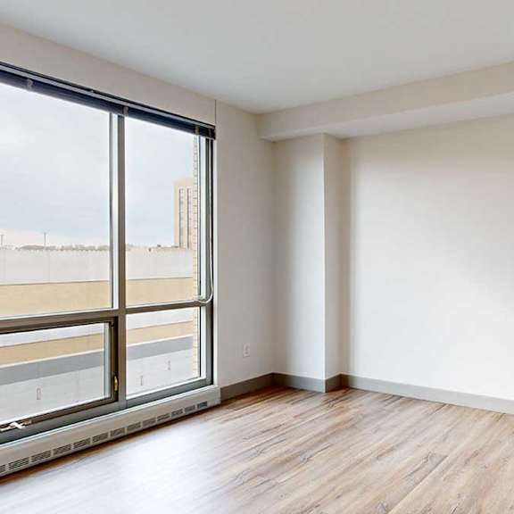 Thumbnail 14 of 24 a bedroom with white walls, a floor to ceiling window, and hardwood floors
