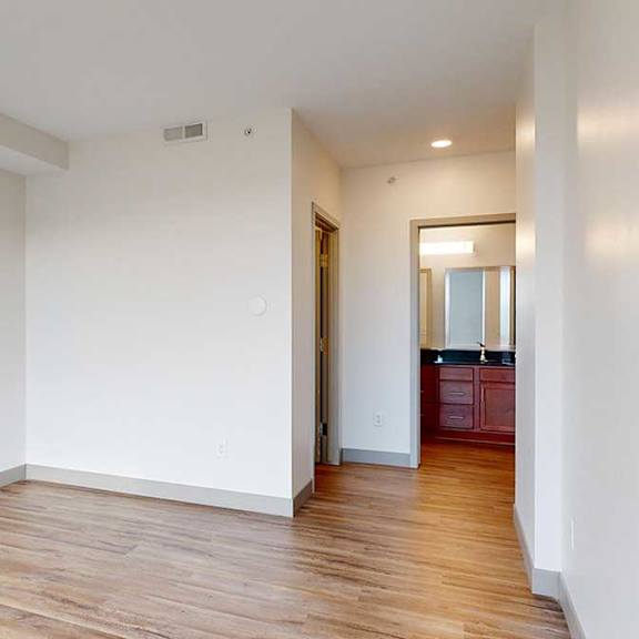 Thumbnail 16 of 24 a bedroom with wooden floor, a walk-in closet, and attached bathroom