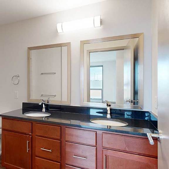 Thumbnail 17 of 24 a bathroom with a double vanity sink with black granite counter tops, and two mirrors
