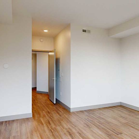 Thumbnail 20 of 24 a bedroom with hallway at the entrance and hardwood floors