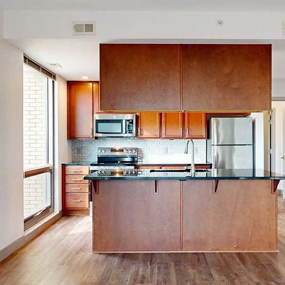 Thumbnail 7 of 24 a modern kitchen with a central island with brown overhead wooden cabinets