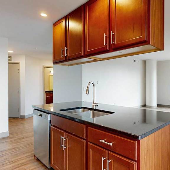 Thumbnail 10 of 24 a kitchen with brown wooden cabinets and black granite countertops