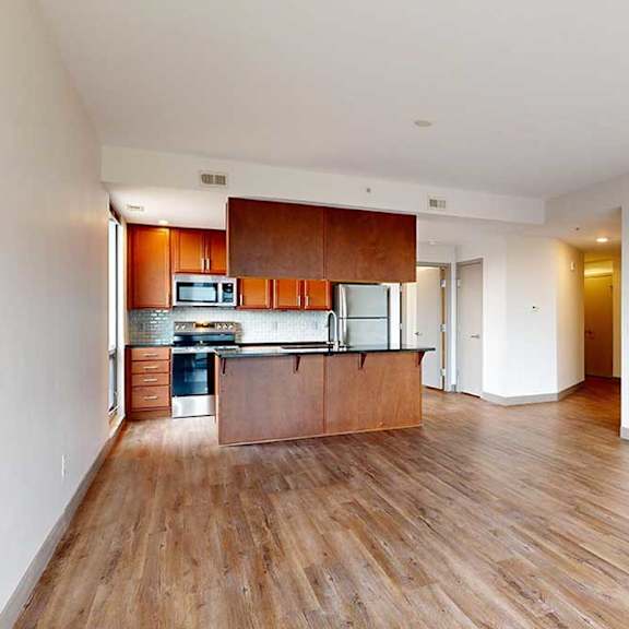Thumbnail 5 of 24 a kitchen and living room with wooden floors and white walls