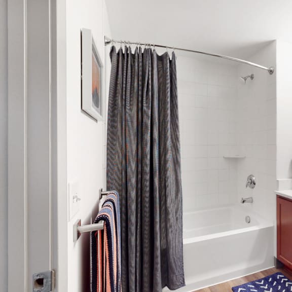 Thumbnail 10 of 14 Spacious bathroom with tub and shower and large vanity in a 1 bedroom floor plan Midtown Crossing Apartments Omaha