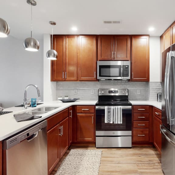Thumbnail 3 of 14 Spacious kitchen with peninsula and quartz or granite counter top and tile back splash in a 1 bedroom floor plan at Midtown Crossing Apartments Omaha