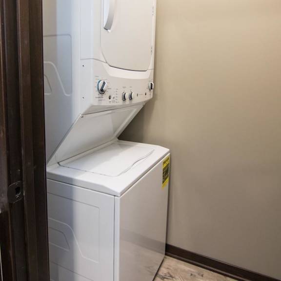 Thumbnail 4 of 9 A white washing machine in a small room.