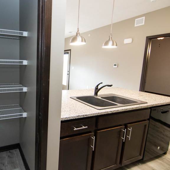 Thumbnail 3 of 9 A kitchen with a refrigerator and a sink.