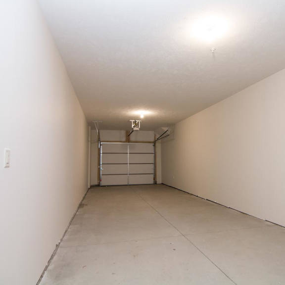 Thumbnail 13 of 13 An empty tandem garage with door closed