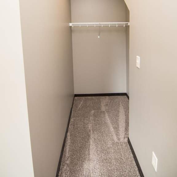 Thumbnail 10 of 13 A long, narrow closet with a shelf and a light on the ceiling.