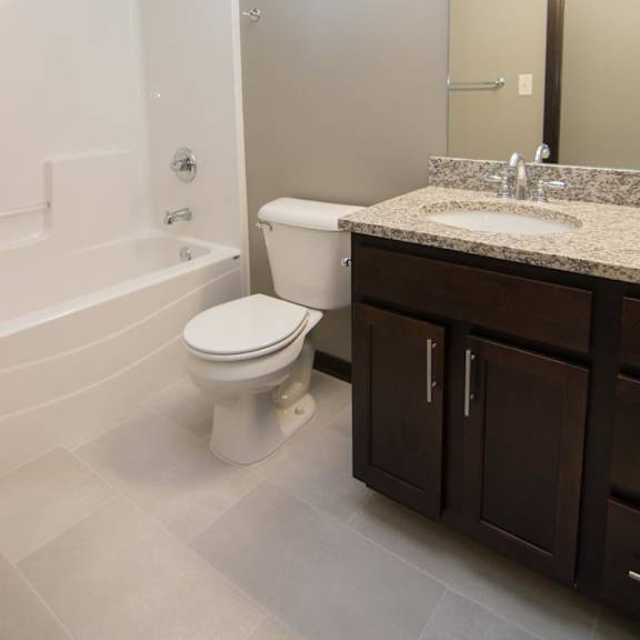 Thumbnail 11 of 13 A bathroom with a toilet, sink, and bathtub.