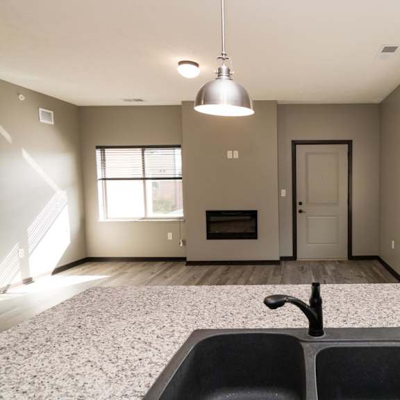Thumbnail 4 of 13 A kitchen with a black sink and granite countertop.