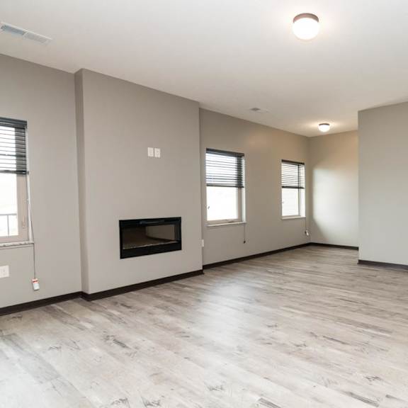 Thumbnail 4 of 14 A spacious living room with a fireplace and and light brown floors