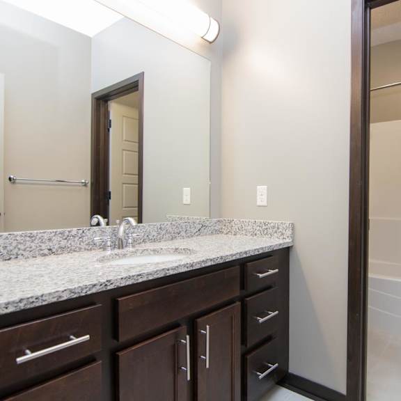 Thumbnail 10 of 14 A bathroom with a sink, mirror, and bathtub.