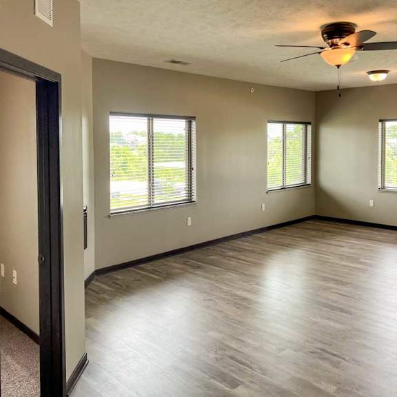 Thumbnail 2 of 20 a living room with several large windows and hardwood flooring