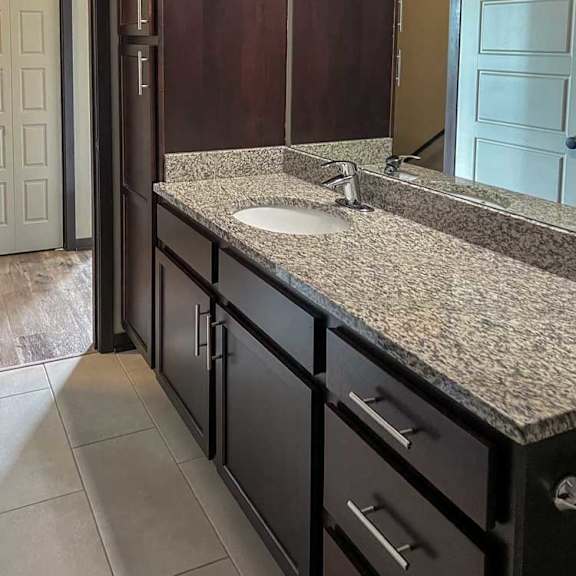 Thumbnail 17 of 20 a bathroom with a granite vanity sink and a mirror