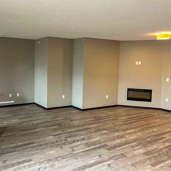 Thumbnail 4 of 13 a living room with hardwood flooring and a fireplace next to the kitchen