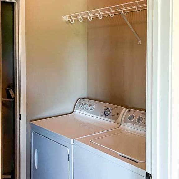 Thumbnail 3 of 15 a side by side washer and dryer with overhead shelving in a double door closet at the top of the entryway