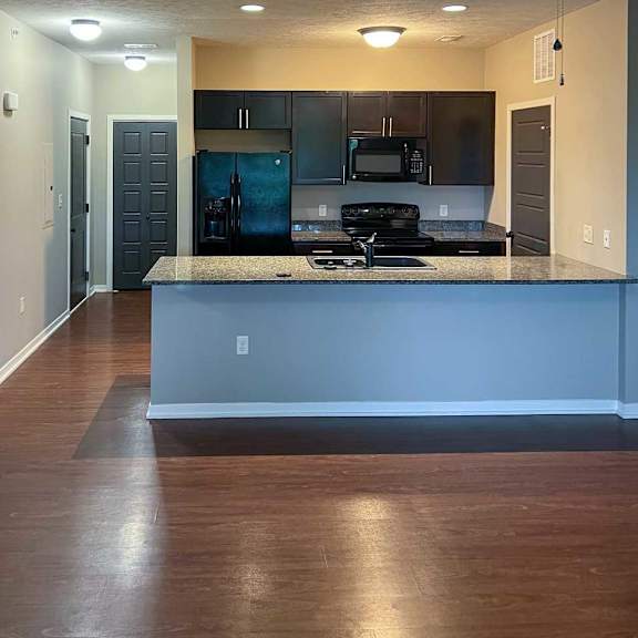 Thumbnail 5 of 35 a kitchen with dark wooden cabinets, granite countertops, and black appliances