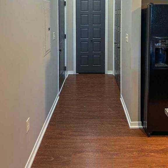 Thumbnail 13 of 35 a long hallway with a coat closet and access to the garage at the end