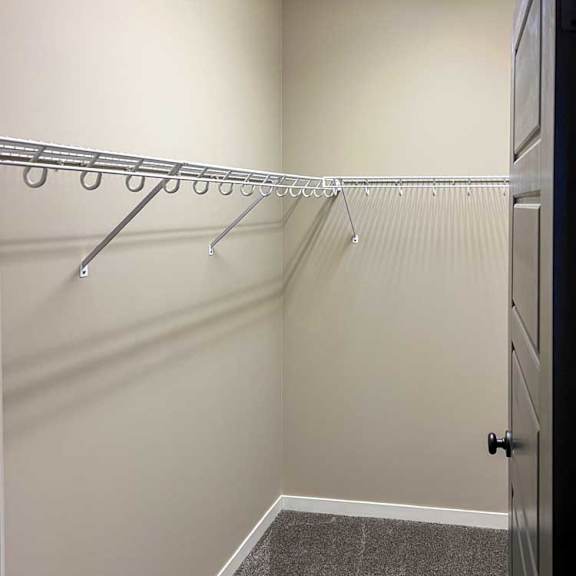 Thumbnail 9 of 35 a carpeted walk-in closet with built-in shelving and hanging space