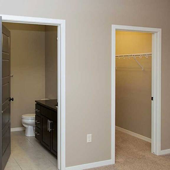 Thumbnail 33 of 35 a bedroom with carpeted flooring, and an attached bathroom and walk-in closet