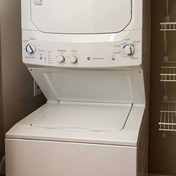Thumbnail 32 of 35 a stackable washer and dryer in a laundry closet with built-in shelving