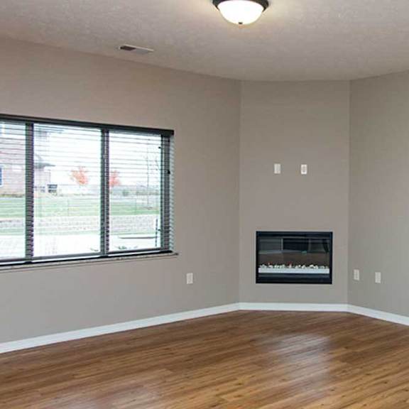 Thumbnail 29 of 35 a living room with hardwood flooring, a large three-panel window, a ceiling fan, and a fireplace