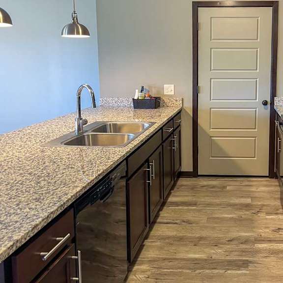 Thumbnail 18 of 35 a kitchen with dark wooden cabinets, granite countertops, hardwood flooring, and black appliances