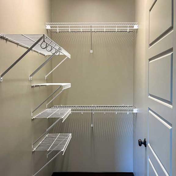 Thumbnail 22 of 35 a walk-in closet with built-in shelving and a carpeted floor