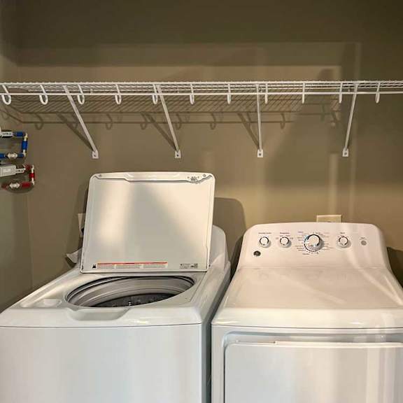 Thumbnail 19 of 19 a full-sized side-by-side washer and dryer in a closet with overhead shelf storage