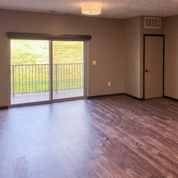 Thumbnail 9 of 19 a living room with a sliding glass door to the balcony, and a closet