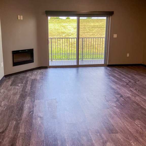Thumbnail 10 of 19 a living room with a fireplace and a sliding glass door to the balcony