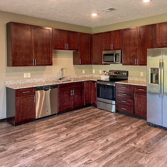 Thumbnail 7 of 19 a kitchen with warm brown wooden cabinets and stainless steel appliances