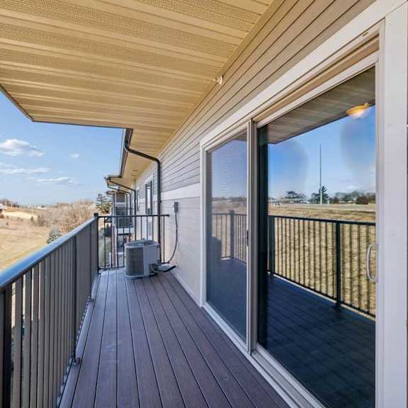 Thumbnail 31 of 37 A balcony with a sliding glass door and a black railing.