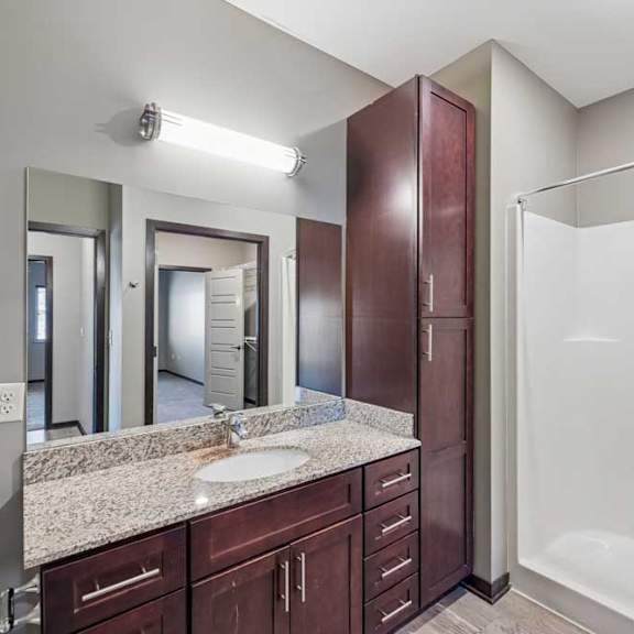 Thumbnail 36 of 37 A bathroom with a sink, mirror, and shower.