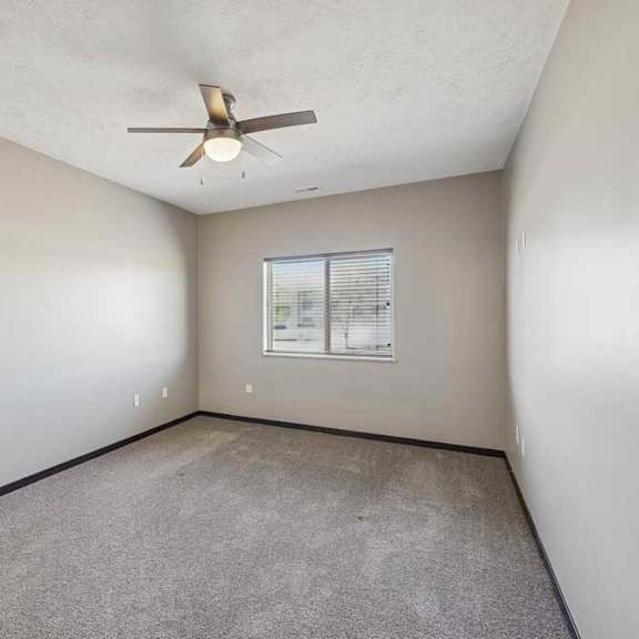 Thumbnail 27 of 37 Empty room with a ceiling fan and a window.