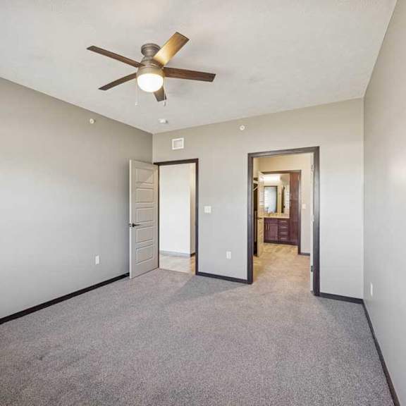 Thumbnail 26 of 37 A room with a ceiling fan and carpeted floor.