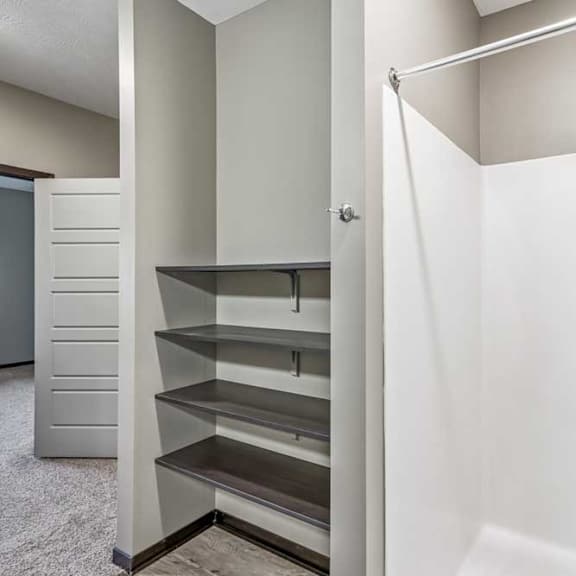 Thumbnail 43 of 51 A white bathroom with a walk-in shower and a small kitchenette.