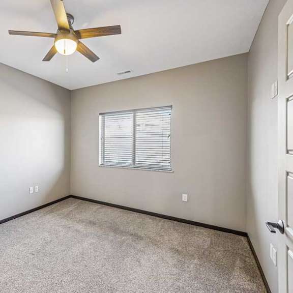Thumbnail 47 of 51 A room with a ceiling fan and a window with blinds.