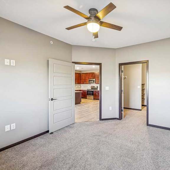 Thumbnail 44 of 51 A room with a ceiling fan and carpeted floor.