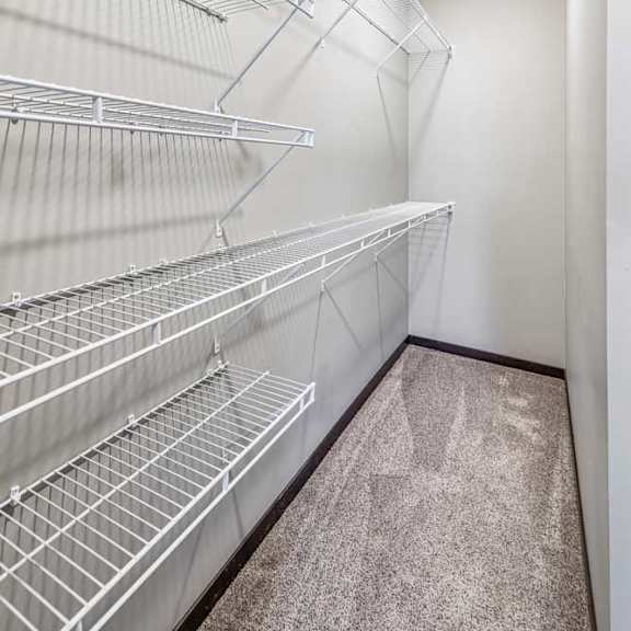 Thumbnail 48 of 51 Empty walk-in closet with white shelving and a carpeted floor.
