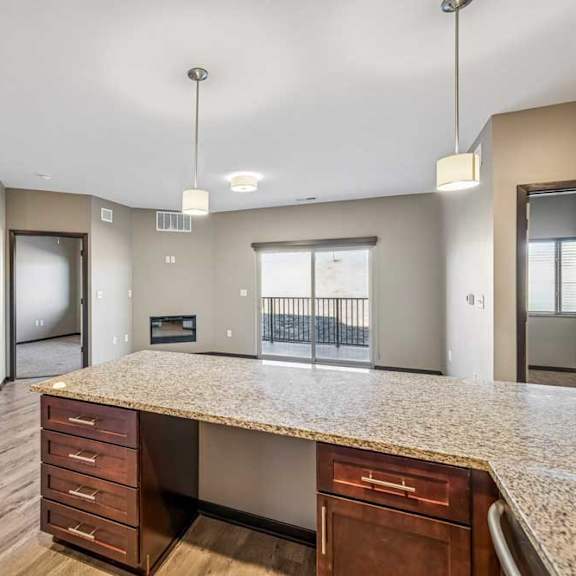Thumbnail 41 of 51 A spacious kitchen with a granite countertop and wooden cabinets.